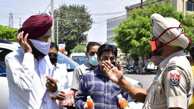 Punjab Police personnel direct commuters during the Covid-19 lockdown, in Amritsar on Monday. (Sameer Sehgal/HT Photo) Punjab Police personnel direct commuters during the Covid-19 lockdown, in Amritsar on Monday. (Sameer Sehgal/HT Photo)