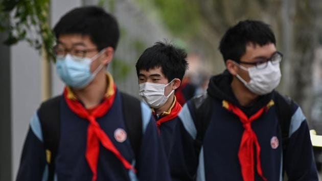 Students wearing face masks arrive at the Huayu Middle School in Shanghai on April 27. Tens of thousands of students returned Chinese school campuses on Monday after months of closures intended to curb the spread of the coronavirus, as China’s major cities stepped closer to normality. (Hector Retamal / AFP)
