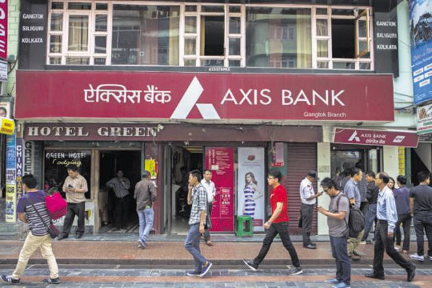 People walk past a branch of Axis Bank Ltd on Mahatma Gandhi Road in Gangtok city of Sikkim in this file photo.(Bloomberg Photo)