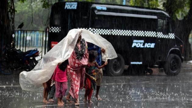 People move towards cover under a plastic sheet while it rains in Kolkata on April 27. Intermittent wet spells have kept maximum temperatures down in the country when the rest of the world is recording above normal temperatures, surprising Indian Meteorological Department (IMD) scientists. (ANI)