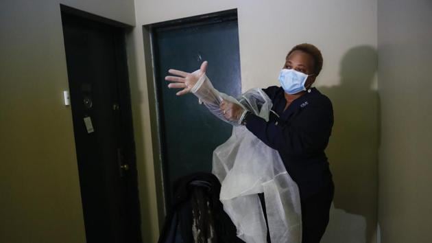 In this Thursday, April 23, 2020 photo, Ruth Caballero, a nurse with The Visiting Nurse Service of New York, puts on personal protective equipment before entering a patient's apartment as she makes her rounds in upper Manhattan in New York. ) (AP) In this Thursday, April 23, 2020 photo, Ruth Caballero, a nurse with The Visiting Nurse Service of New York, puts on personal protective equipment before entering a patient's apartment as she makes her rounds in upper Manhattan in New York. ) (AP)