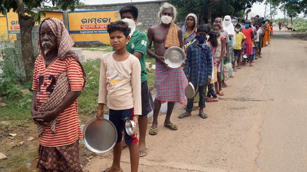 Slum residents stand in a queue to collect free kitchen food distributed by an NGO during the nationwide lockdown in the of coronavirus, in Bhubaneswar on Tuesday. (ANI Photo) (ANI Photo) Slum residents stand in a queue to collect free kitchen food distributed by an NGO during the nationwide lockdown in the of coronavirus, in Bhubaneswar on Tuesday. (ANI Photo) (ANI Photo)