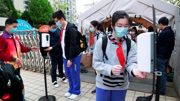 Students use hand sanitizer while on their way into school in Shanghai. Senior students were allowed back to prepare for the all-important “Gaokao” university entrance exam. (Cnsphoto via REUTERS)