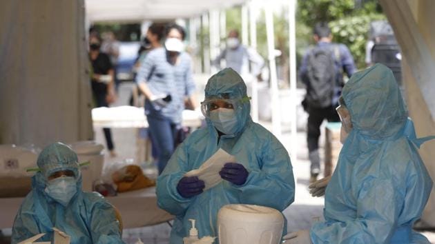 Health workers get ready at a Covid-19 testing center in New Delhi, India. (AP) Health workers get ready at a Covid-19 testing center in New Delhi, India. (AP)