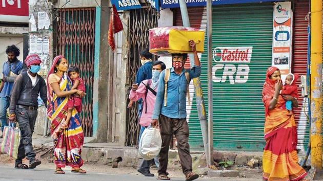 Migrant workers carrying their luggage walk towards their villages in Guwahati on Tuesday.(PTI) Migrant workers carrying their luggage walk towards their villages in Guwahati on Tuesday.(PTI)