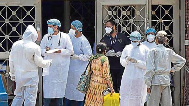 Doctors and other medical staff of Lok Nayak hospital attend to people outside the main building.