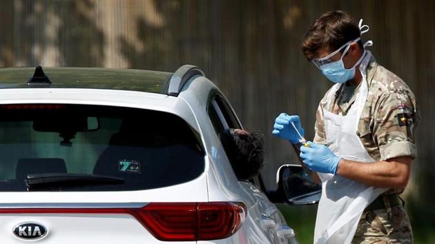 A member of the military conducts a Covid-19 check-up at a drive-thru testing site in Chessington, London, on April 24.(Reuters Photo) A member of the military conducts a Covid-19 check-up at a drive-thru testing site in Chessington, London, on April 24.(Reuters Photo)