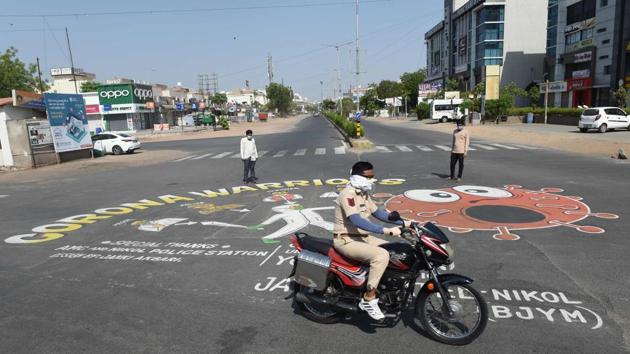 A Gujarat Police personnel rides past a painting to raise awareness about the Covid-19, on the outskirts of Ahmedabad on April 26. (AFP Photo) A Gujarat Police personnel rides past a painting to raise awareness about the Covid-19, on the outskirts of Ahmedabad on April 26. (AFP Photo)