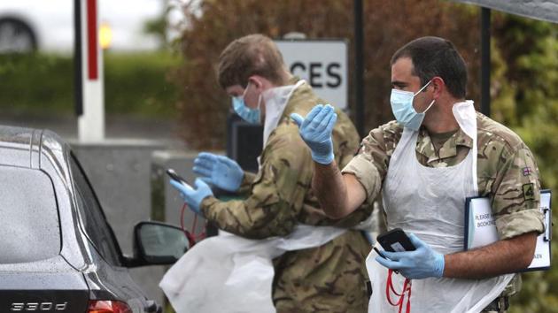 Soldiers provide instructions to people arriving at a Covid-19 testing centre in a Park and Ride facility in Salisbury, England, as the lockdown to help curb the spread of coronavirus continues. (AP) Soldiers provide instructions to people arriving at a Covid-19 testing centre in a Park and Ride facility in Salisbury, England, as the lockdown to help curb the spread of coronavirus continues. (AP)