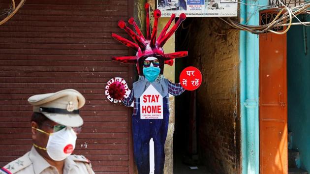 A police officer wearing a protective face mask walks past a novel coronavirus-themed scarecrow cutout put up in a residential area during an extended lockdown to slow the spreading ofthe coronavirus disease (COVID-19) in the old quarters of Delhi. (REUTERS) A police officer wearing a protective face mask walks past a novel coronavirus-themed scarecrow cutout put up in a residential area during an extended lockdown to slow the spreading ofthe coronavirus disease (COVID-19) in the old quarters of Delhi. (REUTERS)
