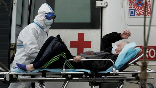 A medical specialist wearing protective gear transports a man on a stretcher outside a hospital for patients infected with the coronavirus disease on the outskirts of Moscow, Russia.(Reuters Photo)