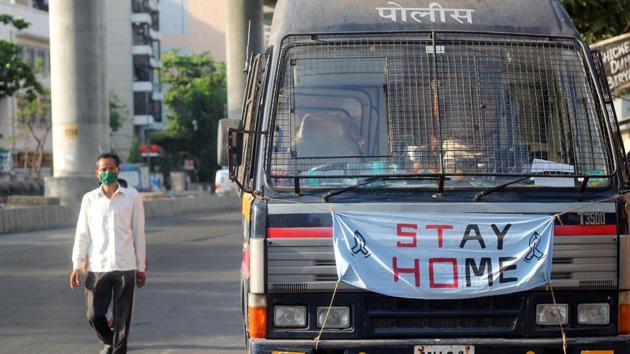 A man walks past a police van with Stay Home message, during the Covid-19 lockdown in Mumbai on Wednesday. (ANI Photo) A man walks past a police van with Stay Home message, during the Covid-19 lockdown in Mumbai on Wednesday. (ANI Photo)