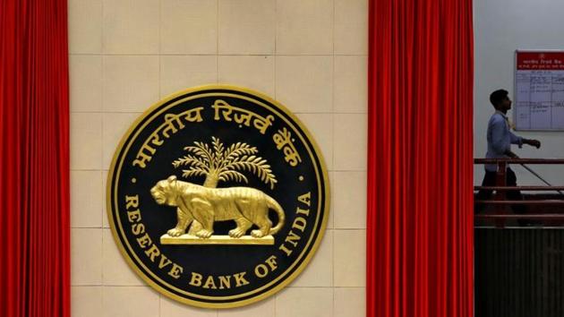 A worker walks past the logo of Reserve Bank of India (RBI) inside its office in New Delhi. (REUTERS)