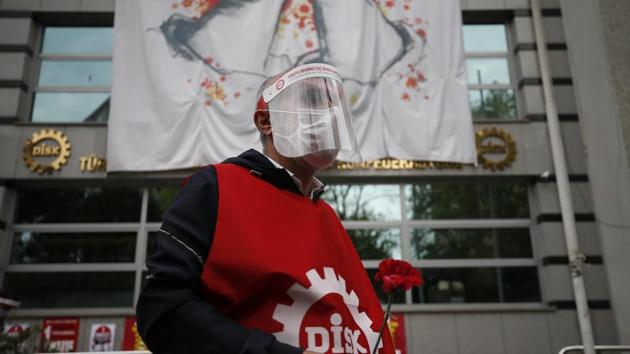 A demonstrator from the Confederation of Progressive Trade Unions of Turkey, or DISK, wearing a face mask and shield for protection against coronavirus, gather during May Day protests in Istanbul. (AP) A demonstrator from the Confederation of Progressive Trade Unions of Turkey, or DISK, wearing a face mask and shield for protection against coronavirus, gather during May Day protests in Istanbul. (AP)