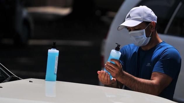 A man sanitising bottles of a sanitiser after buying them from a medical store. (Ravi Kumar/HT) A man sanitising bottles of a sanitiser after buying them from a medical store. (Ravi Kumar/HT)