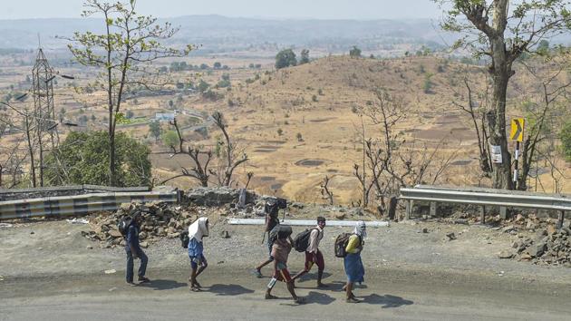 Migrant workers with their belongings journey homewards on the Mumbai-Nashik highway in Thane, on May 1. Millions of workers have been struggling since the lockdown began on March 25, facing a shortage of food and income, and have been seeking to go back home hundreds of kilometres away. Many have chosen to do so even by foot. (Mitesh Bhuvad / PTI)