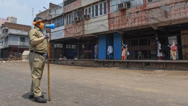 A civil defence personnel speaks on a loudspeaker in Azadpur Mandi. “At the wholesale level, we are taking all possible measures to ensure that prices of fruits and vegetables do not shoot up. Other than that, the market is being sanitised more frequently now, every few hours,” chairperson of Azadpur APMC, Adil Khan told HT. (Sanchit Khanna / HT Photo)