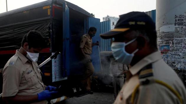 A police officer walks out of a disinfectant van after dispersing a large crowd of migrants after they gathered outside a railway station, during an extended nationwide lockdown to slow the spreading of the coronavirus disease (Covid-19), in Mumbai. (REUTERS) A police officer walks out of a disinfectant van after dispersing a large crowd of migrants after they gathered outside a railway station, during an extended nationwide lockdown to slow the spreading of the coronavirus disease (Covid-19), in Mumbai. (REUTERS)