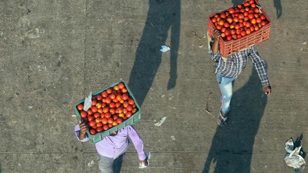 Workers carry crates of tomatoes at Ghazipur Mandi during the ongoing lockdown to curb the spread of coronavirus (COVID-19) disease. Delhi’s wholesale markets are dealing with a gradual disruption in the supply of fruits and vegetables, which is set to send retail prices soaring, as neighbouring states have sealed borders with the Capital. (ANI)