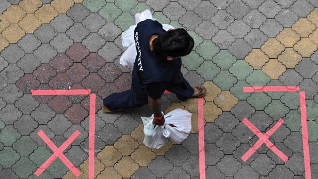 A security guard carrying bags of takeaway food walks past safe distance markers, as a protective measure against the spread of the Covid-19 novel coronavirus, in Singapore on May 2, 2020. (AFP photo) A security guard carrying bags of takeaway food walks past safe distance markers, as a protective measure against the spread of the Covid-19 novel coronavirus, in Singapore on May 2, 2020. (AFP photo)