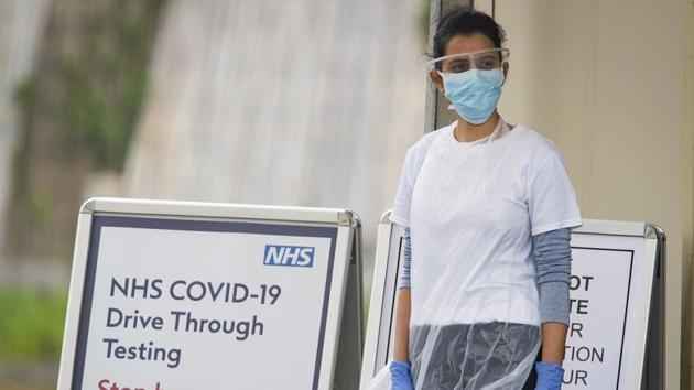A medical worker waits at a drive-in coronavirus testing facility at the Chessington World of Adventures Resort in Chessington, England. (AP) A medical worker waits at a drive-in coronavirus testing facility at the Chessington World of Adventures Resort in Chessington, England. (AP)