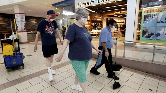 A couple wearing face masks walk past a maintenance worker at the Gateway shopping mall in Lincoln, Nebraska., Friday, May 1, 2020. (AP) A couple wearing face masks walk past a maintenance worker at the Gateway shopping mall in Lincoln, Nebraska., Friday, May 1, 2020. (AP)