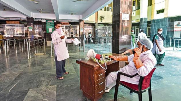 A doctor sits near the registration counter to assist people after OPD began functioning at Civil Hospital, Lucknow on April 21.