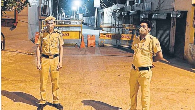 Delhi Police personnel stand guard outside a barricaded lane in Kapashera area, where 41 people of the same building, sealed on April 19, tested positive for the coronavirus disease. (Vipin Kumar/HT PHOTO) Delhi Police personnel stand guard outside a barricaded lane in Kapashera area, where 41 people of the same building, sealed on April 19, tested positive for the coronavirus disease. (Vipin Kumar/HT PHOTO)