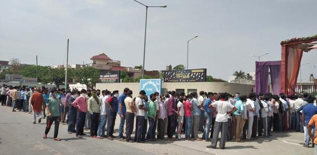 Migrant labourers gathered outside a resort in Moti Nagar to collect ration in Ludhiana on Saturday. (Gurpreet Singh//HT) Migrant labourers gathered outside a resort in Moti Nagar to collect ration in Ludhiana on Saturday. (Gurpreet Singh//HT)