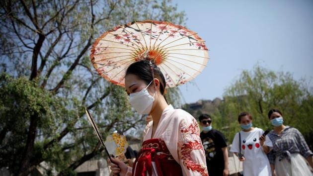 A woman wearing face mask and traditional Chinese clothing visits Gubei Water Town on the first day of the five-day Labour Day holiday, following the coronavirus disease (Covid-19) outbreak, on the outskirts of Beijing, China.(REUTERS) A woman wearing face mask and traditional Chinese clothing visits Gubei Water Town on the first day of the five-day Labour Day holiday, following the coronavirus disease (Covid-19) outbreak, on the outskirts of Beijing, China.(REUTERS)