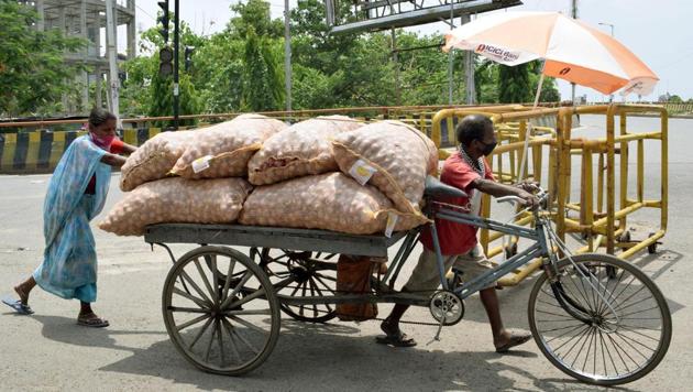 A couple carrying sacks of onions on a rickshaw cart in Patna on Sunday amid the lockdown.(Santosh Kumar/HT PHOTO)