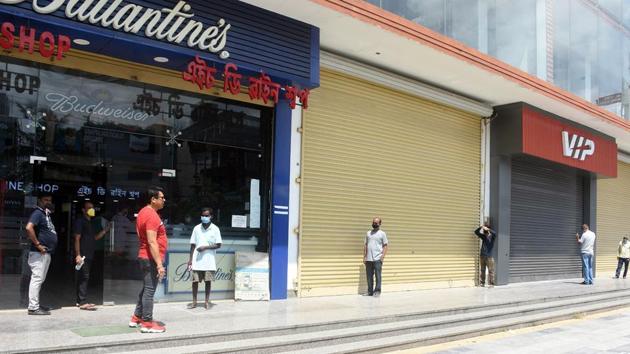 People maintain social distance as they stand in queue outside a wine shop tin Guwahatii.(ANi)