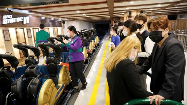 People wearing protective face masks to avoid the spread of the coronavirus disease (Covid-19), wait to ride a roller coaster at an amusement park in Seoul, South Korea.(REUTERS)