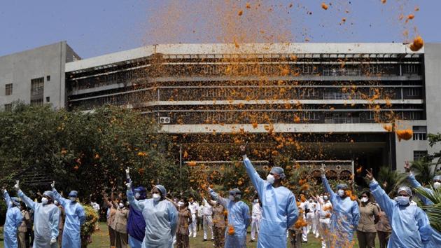An Indian Air Force (IAF) helicopter showers flower petals on the staff of INHS Asvini hospital in Mumbai. Twenty-three hospitals dedicated to treating coronavirus disease (Covid-19) patients were showered with petals from the air across the country. (Rajanish Kakade / AP) An Indian Air Force (IAF) helicopter showers flower petals on the staff of INHS Asvini hospital in Mumbai. Twenty-three hospitals dedicated to treating coronavirus disease (Covid-19) patients were showered with petals from the air across the country. (Rajanish Kakade / AP)