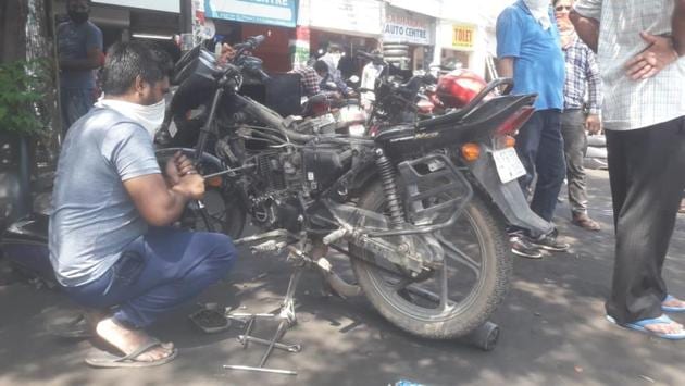 A worker repairs a two wheeler in Mohali, Punjab. In orange zones, all the activities in red zones and in addition -- taxis are allowed, provided they are carrying only two passengers, as is travel between districts for permitted activities. (Gurminder Singh / HT Photo)