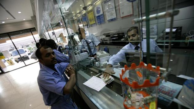 A migrant labourer arranges to send money home via a bank in Sharjah, United Arab Emirates.(Getty Images)