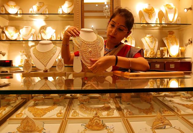 A saleswoman displays a gold necklace inside a jewellery showroom on the occasion of Akshaya Tritiya, a major gold buying festival, in Kolkata, in this file photo.(Reuters Photo)