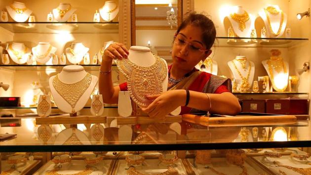 A saleswoman displays a gold necklace inside a jewellery showroom on the occasion of Akshaya Tritiya, a major gold buying festival, in Kolkata, India, May 7, 2019. (REUTERS) A saleswoman displays a gold necklace inside a jewellery showroom on the occasion of Akshaya Tritiya, a major gold buying festival, in Kolkata, India, May 7, 2019. (REUTERS)