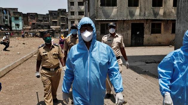 Health workers wearing hazmat suits and masks are accompanied by police officers as they conduct an inspection in a residential area, to check for Covid-19, in Dharavi in this file photo. (Reuters Photo) Health workers wearing hazmat suits and masks are accompanied by police officers as they conduct an inspection in a residential area, to check for Covid-19, in Dharavi in this file photo. (Reuters Photo)