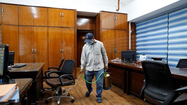 A man wearing a face mask disinfects an office which opened after few restrictions were lifted on Monday, during an extended nationwide lockdown to curb the spread of coronavirus (COVID-19) disease, in New Delhi. In Delhi -- red zones that are not marked as containment zones, government offices providing essential services are allowed to operate at 100 per cent staff capacity, other government and private offices at 33 per cent, reported HT. (Anushree Fadnavis / REUTERS)