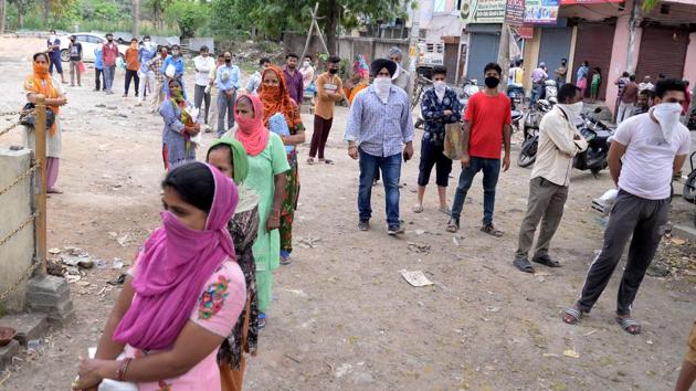 People maintain social distance while waiting in queue to get free essential grocery items by government, during a coronavirus lockdown in Jalandhar on Sunday. (ANI Photo) People maintain social distance while waiting in queue to get free essential grocery items by government, during a coronavirus lockdown in Jalandhar on Sunday. (ANI Photo)