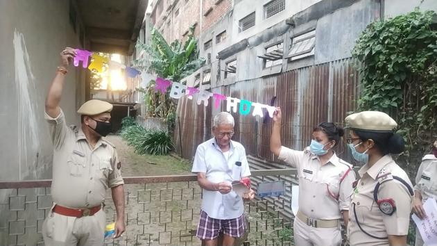 Two police personnel are seen holding a Happy Birthday banner for KP Agarwal in Assam’s Nagaon. They helped Agarwal, whose family is stranded across the country, celebrate his 78th birthday.(Photos: HT/Sourced)