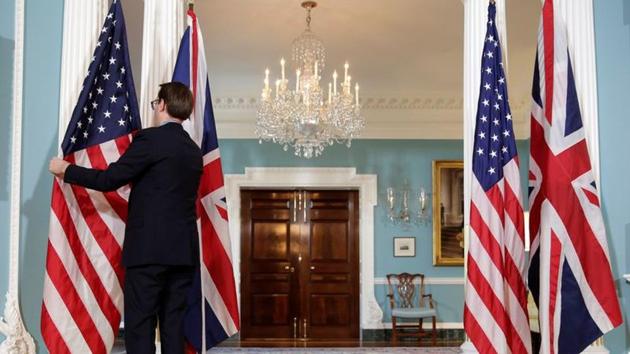 A State Department employee adjusts flags before a cancelled bi-lateral photo between US Secretary of State Rex Tillerson and British Foreign Minister Boris Johnson at the State Department in Washington, US March 22, 2017.(REUTERS)