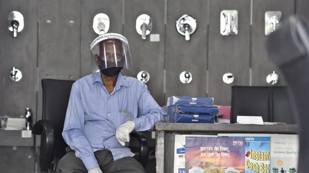 A sales person wearing a face shield at a sanitary hardware shop in Vasant Vihar market in New Delhi. (Ajay Aggarwal /HT PHOTO) A sales person wearing a face shield at a sanitary hardware shop in Vasant Vihar market in New Delhi. (Ajay Aggarwal /HT PHOTO)