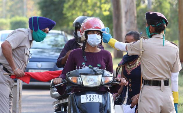 Police using thermal scanners on commuters at a naka at YPS Chowk near Mohali-Chandigarh border on Tuesday. (Gurminder Singh/HT) Police using thermal scanners on commuters at a naka at YPS Chowk near Mohali-Chandigarh border on Tuesday. (Gurminder Singh/HT)