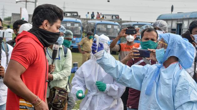 A health worker checks the body temperature of a student after he arrived by bus from other states to West Bengal during the nationwide lockdown as a preventive measure against the Covid-19 pandemic.(AFP PHOTO.)