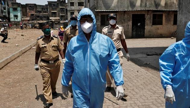 Health workers wearing hazmat suits and masks are accompanied by police officers as they conduct an inspection in a residential area, during a nationwide lockdown in India to slow the spread of Covid-19 in Mumbai’s Dharavi. (Reuters File Photo) Health workers wearing hazmat suits and masks are accompanied by police officers as they conduct an inspection in a residential area, during a nationwide lockdown in India to slow the spread of Covid-19 in Mumbai’s Dharavi. (Reuters File Photo)