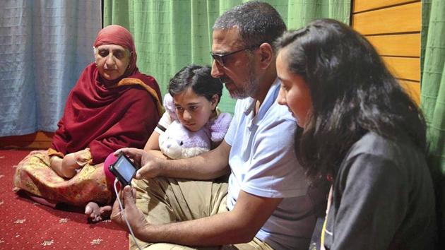 Associated Press photographer Dar Yasin, second right, with his family watches the Pulitzer Prize announcement via video conferencing from his home in Srinagar, Kashmir, following the announcement that he was one of three AP photographers who won the Pulitzer Prize in Feature Photography for their coverage of the conflict in Kashmir. (Rifat Yasin / AP)