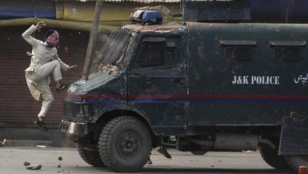 A masked Kashmiri protester jumps on the bonnet of a vehicle belonging to the security forces as he throws stones at it during a protest in Srinagar on May 31, 2019. The image was part of a series of photographs by Associated Press photographers which won the 2020 Pulitzer Prize for Feature Photography. (Dar Yasin / AP)