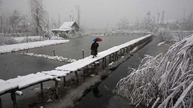 A Kashmiri man walks on a snow covered footbridge in the interiors of Dal Lake in Srinagar on December 13, 2019. The image was part of a series of photographs by Associated Press photographers which won the 2020 Pulitzer Prize for Feature Photography. (Dar Yasin / AP)